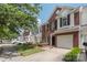 View of townhomes with brick and vinyl exteriors, garage parking, and well-maintained lawns at 10225 Alexander Martin Ave, Charlotte, NC 28277