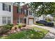 Brick and vinyl two-story townhome featuring a one car garage, dark shutters and landscaped front yard at 10225 Alexander Martin Ave, Charlotte, NC 28277