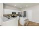 Bright kitchen offers white cabinets, stainless appliances, brick backsplash and island with seating at 10225 Alexander Martin Ave, Charlotte, NC 28277