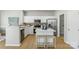 Well-lit kitchen with white cabinets, stainless steel appliances, and a breakfast bar at 10225 Alexander Martin Ave, Charlotte, NC 28277
