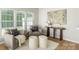 Living room with large windows, two comfy chairs, two stools and shag carpet at 10225 Alexander Martin Ave, Charlotte, NC 28277