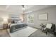 Main bedroom features a tray ceiling, cozy sitting chair, and plush bedding at 10225 Alexander Martin Ave, Charlotte, NC 28277