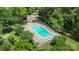 Aerial view of a community pool with lounge chairs and a surrounding fence amidst lush greenery at 10225 Alexander Martin Ave, Charlotte, NC 28277
