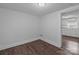 Empty room featuring hardwood floors, neutral paint, and access to kitchen at 103 Garfield Ave, Albemarle, NC 28001