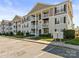 Spacious condo building with multiple floors, balconies, and ample parking spaces in a well-maintained community at 1104 Plaza Walk Dr, Charlotte, NC 28215
