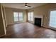 Spacious living room featuring a fireplace, ceiling fan, multiple windows, and wood flooring at 12378 Swan Wings Pl, Huntersville, NC 28078