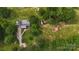 A charming property featuring a gray roof, solar panels, lush landscaping, and outbuildings, set in a private and serene location at 1238 Carl Allen Rd, Edgemoor, SC 29712