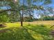 Lush backyard featuring a large tree providing ample shade and an expansive pastoral view, ideal for relaxing at 1238 Carl Allen Rd, Edgemoor, SC 29712