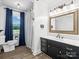 Bright bathroom with dark vanity, framed mirror, and shower with a black and white patterned shower curtain at 1238 Carl Allen Rd, Edgemoor, SC 29712