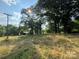 A rustic outbuilding nestled in a field of tall grass beneath mature trees, exuding rural charm and tranquility at 1238 Carl Allen Rd, Edgemoor, SC 29712
