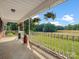 A covered front porch with three hanging plants, a view of the front yard, and red and black vintage containers at 1238 Carl Allen Rd, Edgemoor, SC 29712