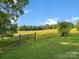 Vast grassy yard with a rustic gate, offering a picturesque and open outdoor space at 1238 Carl Allen Rd, Edgemoor, SC 29712
