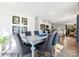 A dining area with a dining table, six chairs, natural light from a window, and view of kitchen at 1549 Cottage Creek Dr, Bessemer City, NC 28016