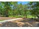 A mulched backyard leads to a tranquil lake with dock, surrounded by mature trees and a serene atmosphere at 16525 Tulloch Rd, Charlotte, NC 28278