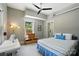 Bedroom features a striped bed, sewing machine, and sunlit window with backyard views at 16525 Tulloch Rd, Charlotte, NC 28278