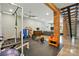 Workout room with brick column, wood stairs, and gray sofa at 16525 Tulloch Rd, Charlotte, NC 28278