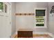 Charming foyer featuring hardwood floors, rustic bench, hooks, and a bright window at 16525 Tulloch Rd, Charlotte, NC 28278
