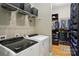 Well-organized laundry room with washer, dryer, storage shelves, and clothes hanging at 16525 Tulloch Rd, Charlotte, NC 28278