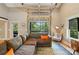 Cozy living room with a gray sectional, glass garage door, and view of surrounding greenery at 16525 Tulloch Rd, Charlotte, NC 28278