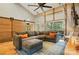 Comfortable living room features a gray sectional sofa, ottoman, and industrial-style sliding door at 16525 Tulloch Rd, Charlotte, NC 28278