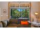 Close-up of sectional sofa, glass garage door with outdoor view, and stylish accent chair at 16525 Tulloch Rd, Charlotte, NC 28278
