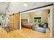 Spacious main bedroom with wooden floors, sliding barn door, and comfortable sitting area at 16525 Tulloch Rd, Charlotte, NC 28278