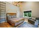 Main bedroom features a rustic bed frame, accent seating and access ladder to an elevated area at 16525 Tulloch Rd, Charlotte, NC 28278