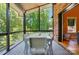 Inviting screened porch with a brick accent wall and outdoor dining set at 16525 Tulloch Rd, Charlotte, NC 28278