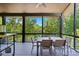 Tranquil screened porch overlooking the lake with dining table and lush trees at 16525 Tulloch Rd, Charlotte, NC 28278