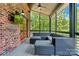 Cozy screened-in porch with TV, brick, ceiling fan, and comfortable outdoor seating at 16525 Tulloch Rd, Charlotte, NC 28278