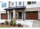 Charming two-story home with white siding, black trim, and wood accents; front entrance view at 1724 Dallas Ave, Charlotte, NC 28205