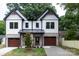 Charming two-story home with white siding, black trim, and wood accents; two-car garage at 1724 Dallas Ave, Charlotte, NC 28205