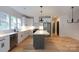 Modern kitchen with stainless steel appliances, white cabinets, a kitchen island, and hardwood floors at 1724 Dallas Ave, Charlotte, NC 28205