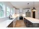 Modern kitchen with an island, white cabinets and quartz countertops and stainless steel appliances at 1724 Dallas Ave, Charlotte, NC 28205