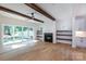 Bright living room with wooden beams, fireplace, and built-in shelves, offering a cozy and stylish space at 1724 Dallas Ave, Charlotte, NC 28205
