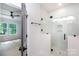 Glass shower in primary bathroom, featuring white tile surround and black hardware at 1724 Dallas Ave, Charlotte, NC 28205