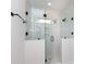 Modern glass-enclosed shower with stone floor, window, and brass hardware, offering a spa-like experience at 1724 Dallas Ave, Charlotte, NC 28205