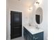 Bathroom features double sinks, a blue vanity, white countertop, black fixtures and mirrors at 1728 Dallas Ave, Charlotte, NC 28205