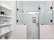Modern bathroom with glass-enclosed shower, built-in shelves, and white tile at 1728 Dallas Ave, Charlotte, NC 28205