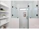 Modern bathroom with glass-enclosed shower, built-in shelves, and white tile at 1728 Dallas Ave, Charlotte, NC 28205