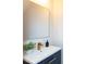 Vanity with dark blue cabinets, quartz counters, modern gold faucet, and square mirror at 1728 Dallas Ave, Charlotte, NC 28205