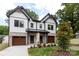 Charming two-story home featuring a brick and white facade, a landscaped front yard, and a two-car garage at 1728 Dallas Ave, Charlotte, NC 28205