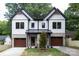 A modern two-story home features gray brick, wood garage doors, black trim, and a well-manicured front yard at 1728 Dallas Ave, Charlotte, NC 28205