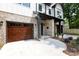 Beautiful two-story home with modern design elements, including a brick facade, dark trim, and wood garage doors at 1728 Dallas Ave, Charlotte, NC 28205