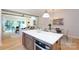 Open-concept kitchen with a center island, modern lighting, and stainless steel appliances that flows into the living room at 1728 Dallas Ave, Charlotte, NC 28205