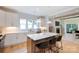 Bright, modern kitchen boasts white cabinetry, hardwood floors, island seating and flows into the living area at 1728 Dallas Ave, Charlotte, NC 28205