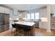 Well-lit kitchen features an island with barstool seating, white cabinets, and stainless steel appliances at 1728 Dallas Ave, Charlotte, NC 28205