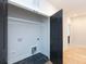 This practical laundry room boasts tile flooring, modern hookups, and a convenient shelf for storage solutions at 1728 Dallas Ave, Charlotte, NC 28205