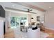 Bright living room with beamed ceilings, fireplace, and sliding doors to a lush, fenced backyard at 1728 Dallas Ave, Charlotte, NC 28205