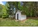 Backyard shed with a star, surrounded by trees, and a fenced area at 17403 Green Hill Rd, Charlotte, NC 28278